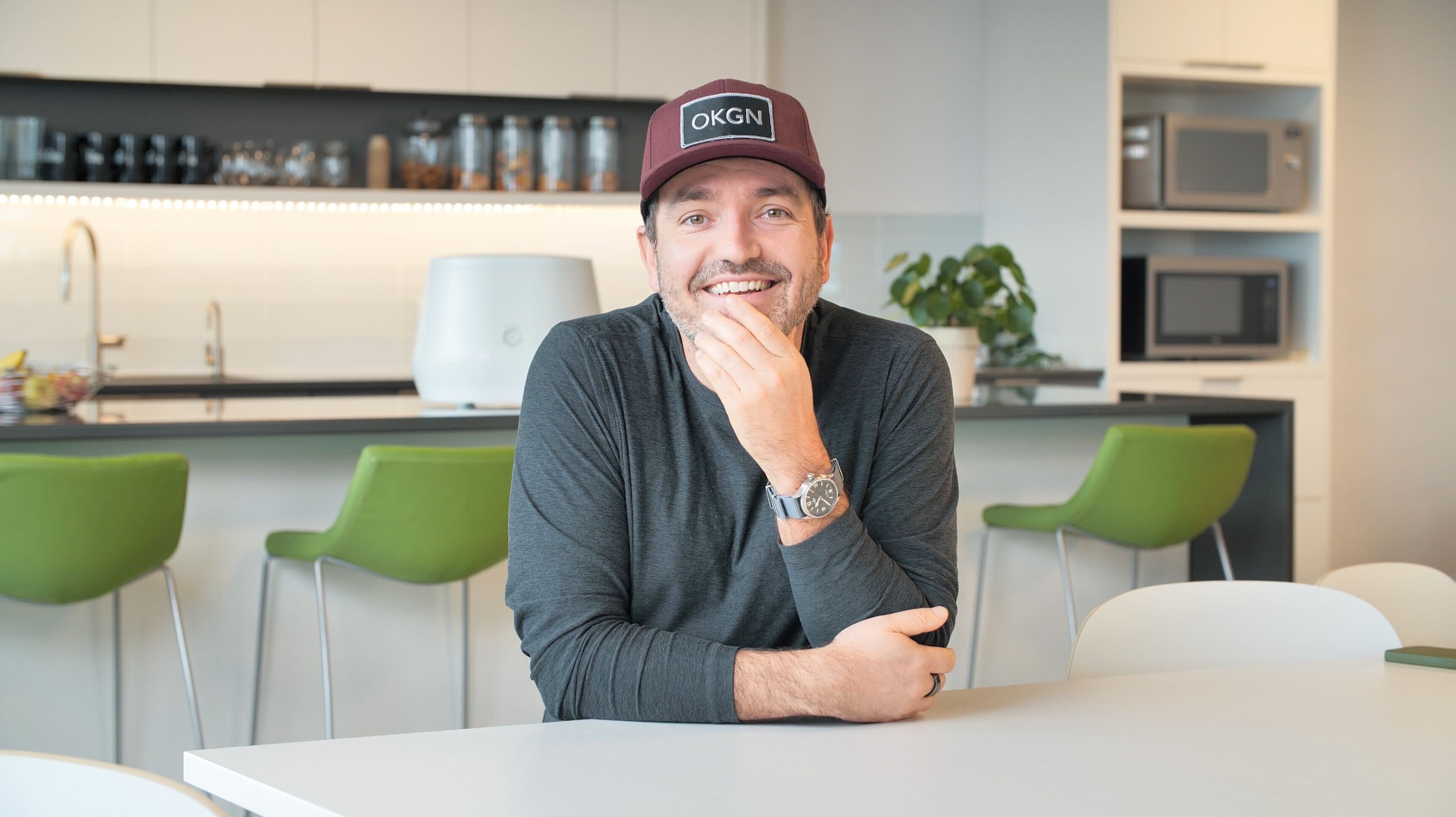 Matt Bertulli smiling in a kitchen, wearing an OKGN cap